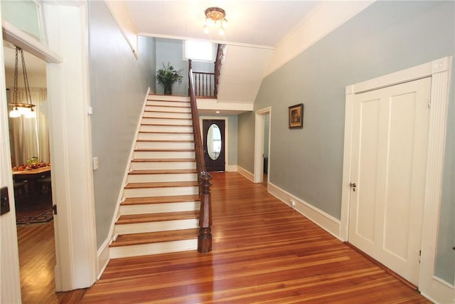 stairs featuring crown molding and dark hardwood / wood-style flooring