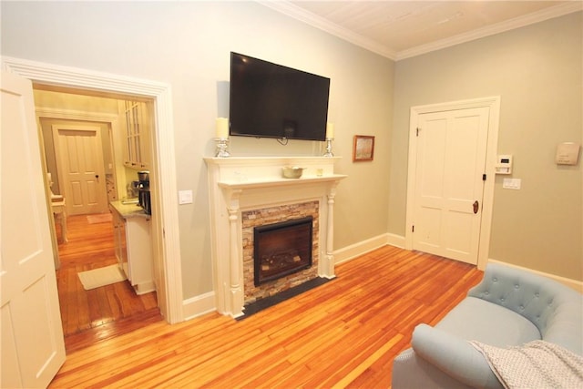 living room featuring crown molding, a fireplace, and light hardwood / wood-style floors