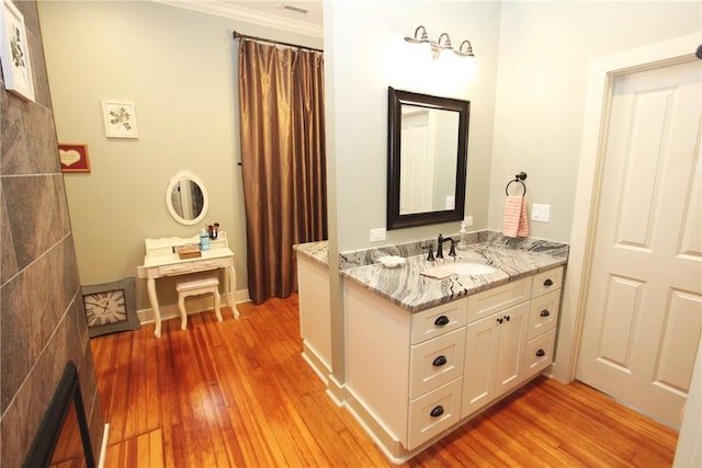 bathroom featuring ornamental molding, vanity, and hardwood / wood-style flooring