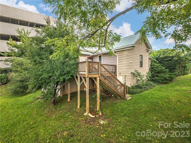 rear view of house featuring a deck and a yard