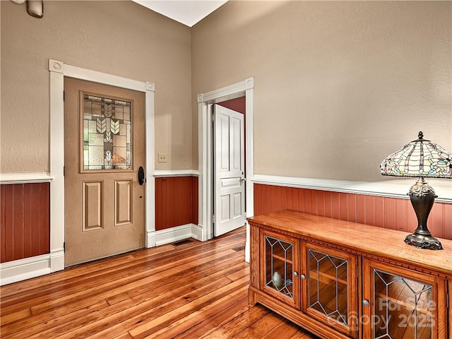 entryway featuring wood-type flooring and wainscoting
