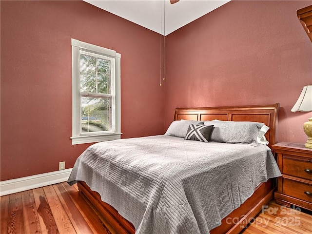 bedroom featuring wood finished floors, a ceiling fan, and baseboards