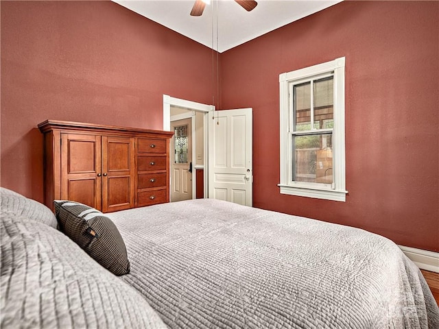 bedroom featuring wood finished floors, a ceiling fan, and baseboards