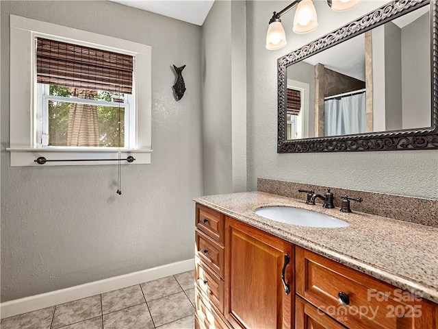 full bathroom with a shower with curtain, baseboards, tile patterned flooring, a textured wall, and vanity