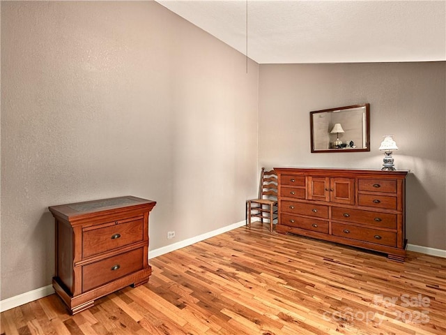 bedroom with light wood finished floors and baseboards