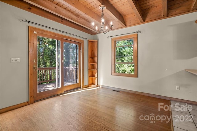 unfurnished room with plenty of natural light, a notable chandelier, beam ceiling, wood ceiling, and light wood-type flooring