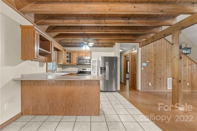 kitchen featuring light tile floors, beam ceiling, ceiling fan, appliances with stainless steel finishes, and sink