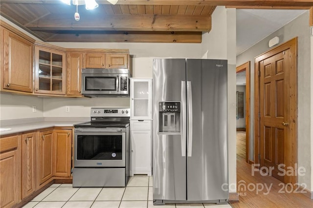 kitchen featuring appliances with stainless steel finishes, beam ceiling, light tile floors, and wooden ceiling