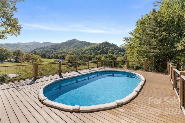 view of pool featuring a deck with mountain view