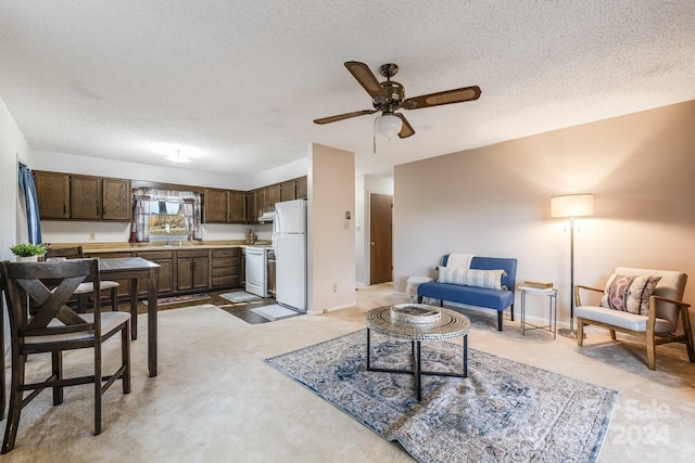 carpeted living room with a textured ceiling, sink, and ceiling fan