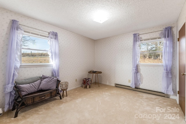 interior space with a textured ceiling, baseboard heating, and light carpet