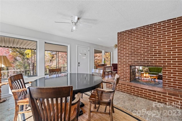 sunroom / solarium with a brick fireplace and ceiling fan