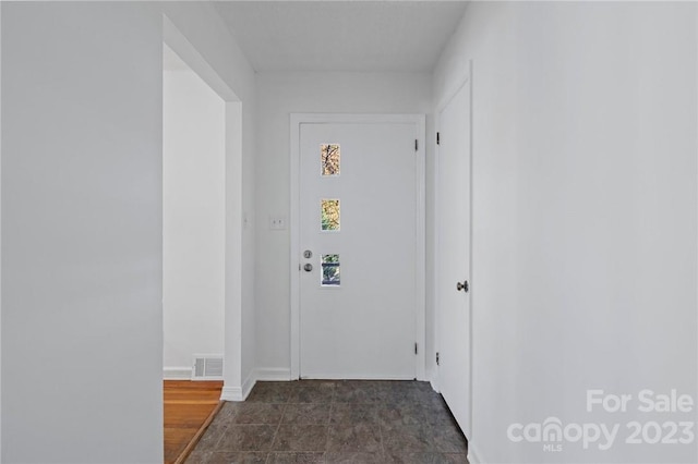 hall with dark tile flooring