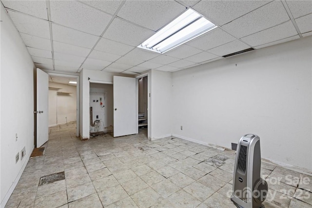 basement featuring light tile flooring and a paneled ceiling