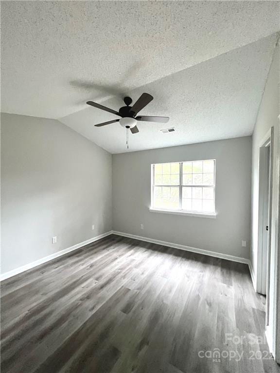 unfurnished room with ceiling fan, dark wood-type flooring, vaulted ceiling, and a textured ceiling