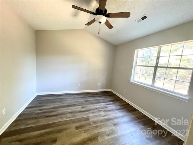 unfurnished room featuring vaulted ceiling, ceiling fan, a textured ceiling, and dark hardwood / wood-style flooring