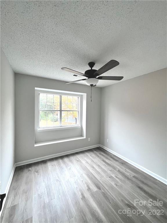 unfurnished room featuring ceiling fan, a textured ceiling, and hardwood / wood-style flooring