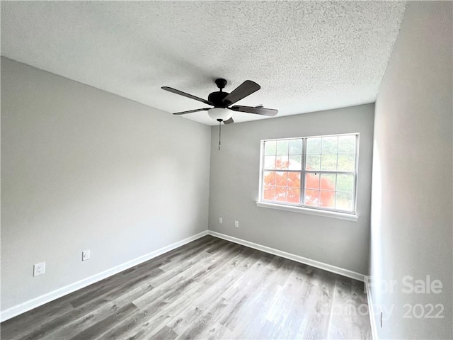 spare room with ceiling fan, a textured ceiling, and hardwood / wood-style flooring