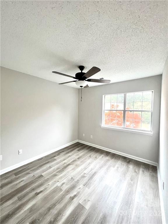 unfurnished room with a textured ceiling, light hardwood / wood-style floors, and ceiling fan