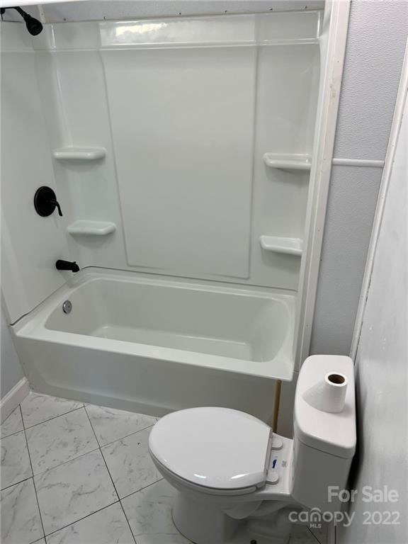 bathroom with washtub / shower combination, tile floors, and toilet