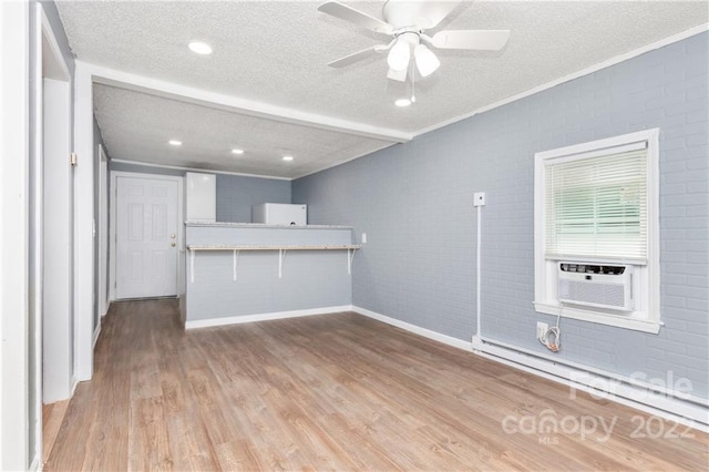 unfurnished living room featuring a textured ceiling, baseboard heating, ceiling fan, and dark hardwood / wood-style flooring