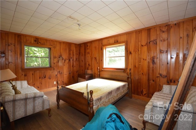 bedroom with wood walls and dark hardwood / wood-style floors