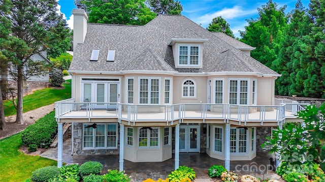 rear view of property with a balcony, a patio, and french doors