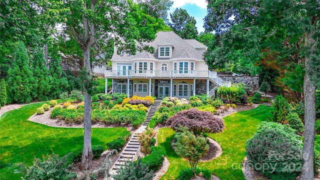 back of house featuring a deck, a yard, and french doors