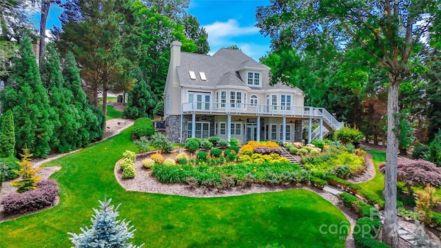 view of front facade featuring french doors, a front yard, and a deck