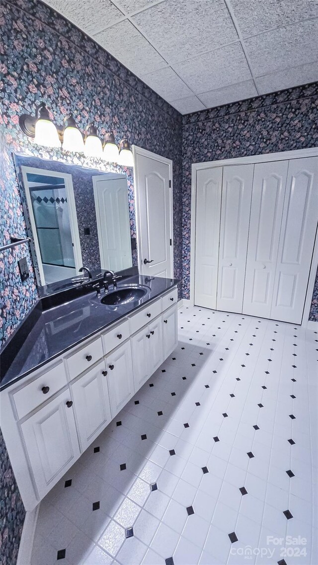 bathroom featuring vanity, tile patterned floors, and a paneled ceiling