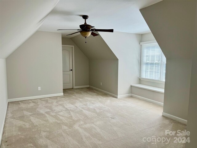 additional living space featuring light colored carpet, ceiling fan, and lofted ceiling