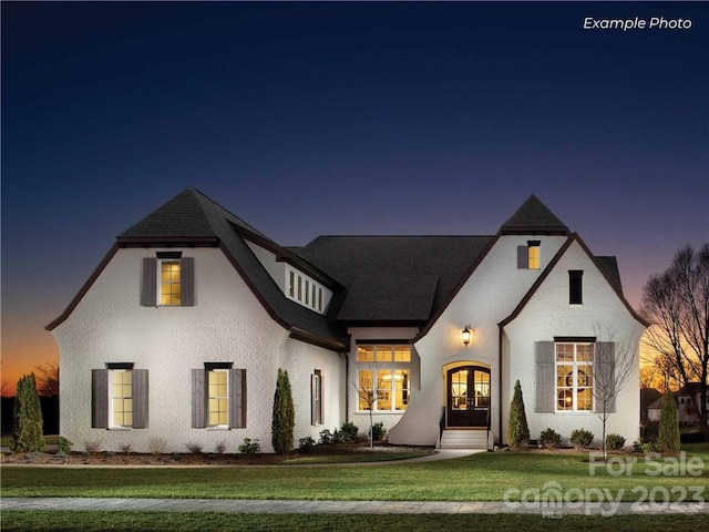 view of front of home featuring a lawn and french doors