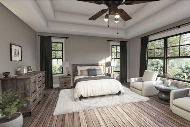 bedroom featuring dark wood-type flooring, ceiling fan, and a tray ceiling