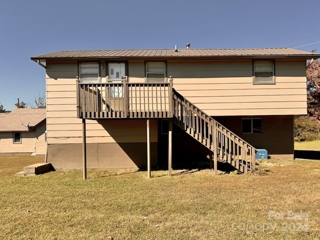 rear view of property featuring a deck and a lawn