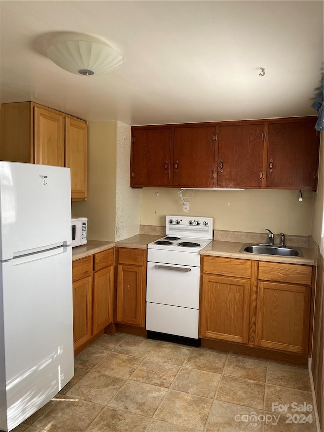 kitchen featuring white appliances and sink