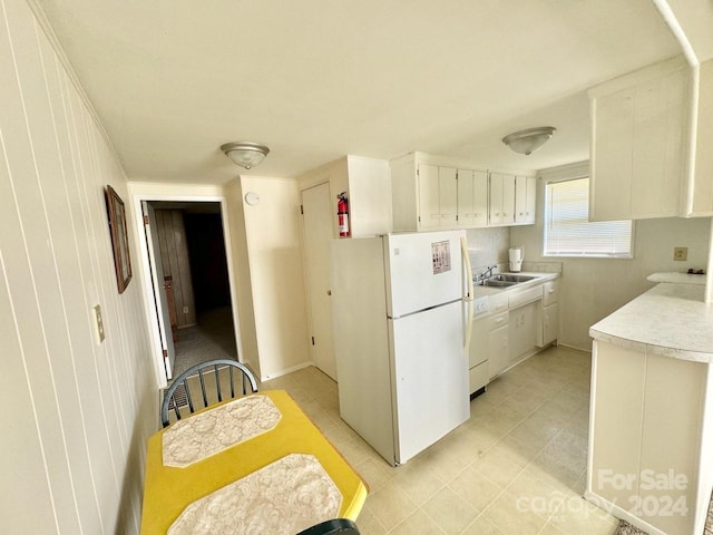 kitchen featuring white refrigerator, sink, and white cabinets