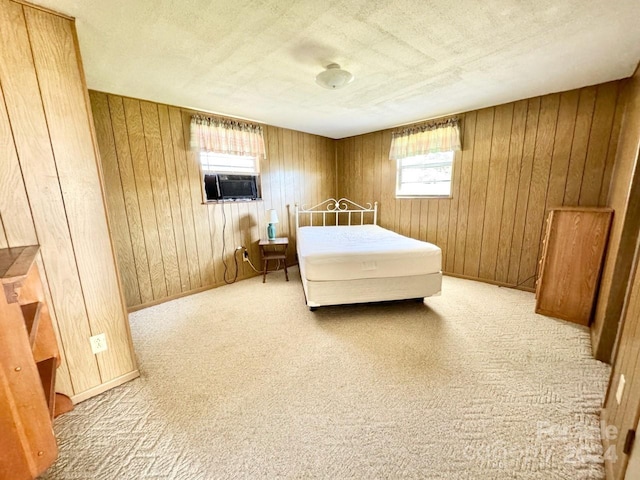 carpeted bedroom with cooling unit, a textured ceiling, and wooden walls