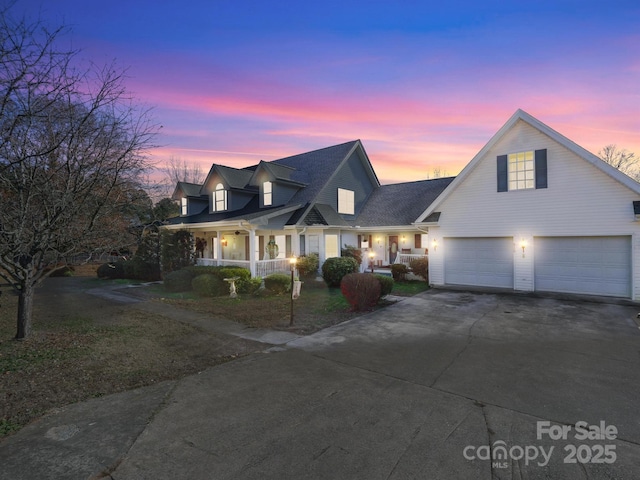 cape cod house with covered porch and a garage