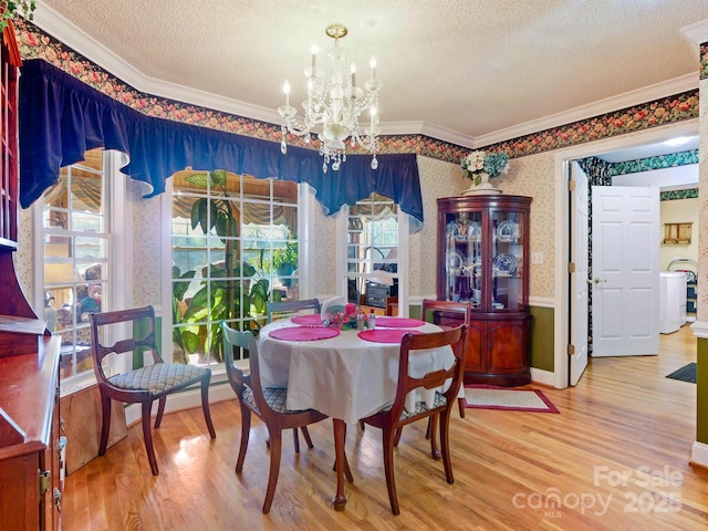 dining area featuring crown molding, hardwood / wood-style floors, a textured ceiling, and a notable chandelier