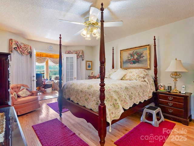 bedroom with access to exterior, ceiling fan, light hardwood / wood-style floors, and a textured ceiling