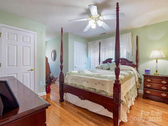 bedroom featuring a textured ceiling, light hardwood / wood-style floors, and ceiling fan