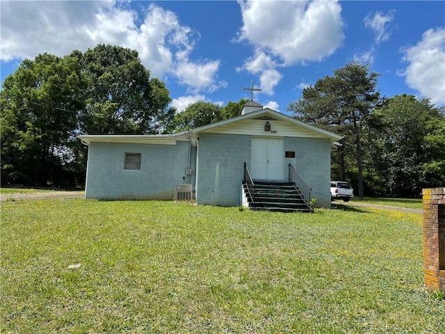 back of house with central air condition unit and a yard