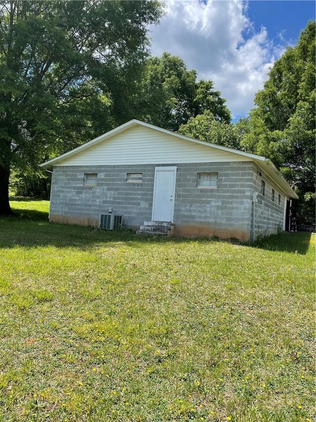 exterior space with central air condition unit and a lawn