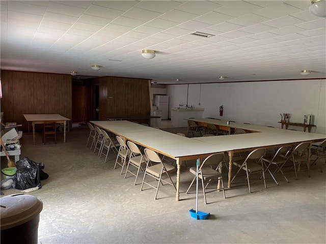 dining space featuring wood walls