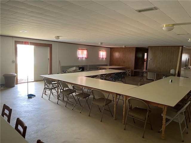 kitchen with wooden walls, a wealth of natural light, and a kitchen bar