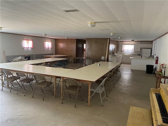 kitchen featuring wood walls, concrete flooring, and kitchen peninsula