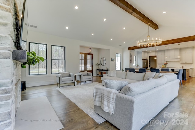 living room featuring vaulted ceiling with beams, light hardwood / wood-style floors, and a notable chandelier