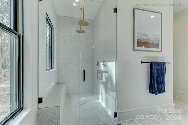 bathroom featuring tile floors, a shower with shower door, and a healthy amount of sunlight