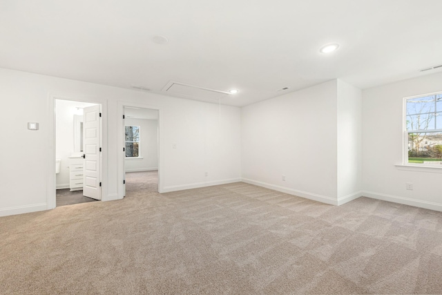 unfurnished bedroom featuring connected bathroom and light colored carpet