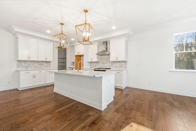 kitchen featuring decorative light fixtures, dark wood-type flooring, wall chimney exhaust hood, and white cabinets